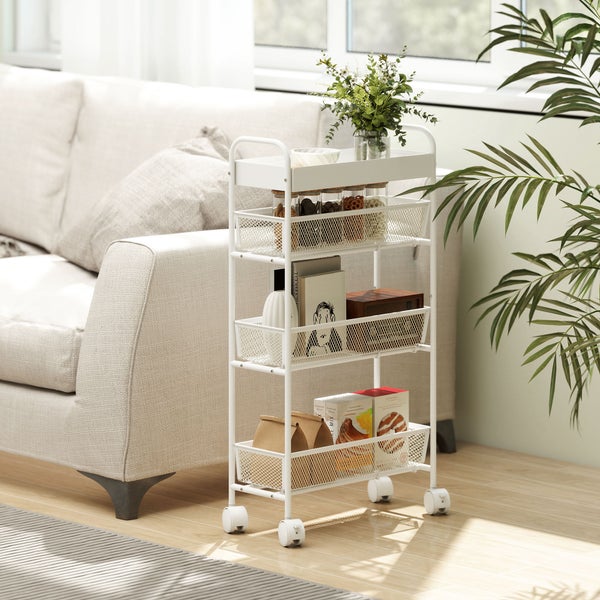 Weißer Rollwagen mit vier Etagen aus Metall neben einem Sofa im Wohnzimmer. Der Wagen hat Gitterkörbe und Rollen.