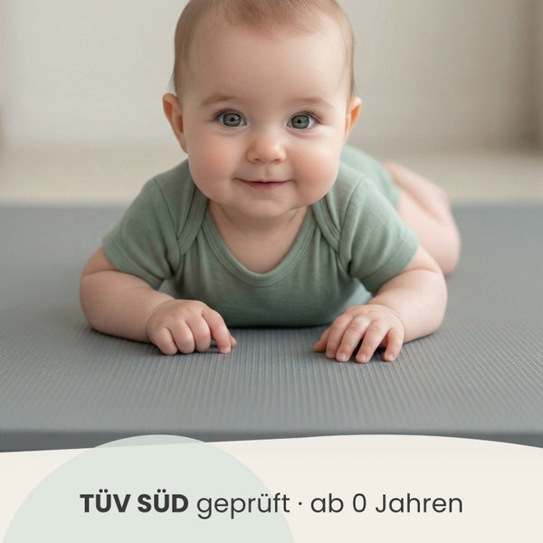 Ein Baby liegt auf einer strukturierten Spielmatte, die TÜV SÜD geprüft und ab null Jahren geeignet ist.