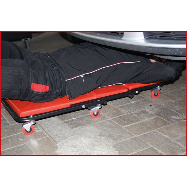 KS Tools Roll-Liege für die Werkstatt mit gepolsterter roter Liegefläche und sechs Lenkrollen.