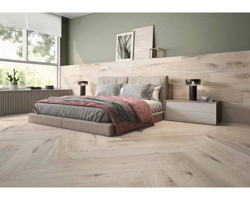 Modernes Schlafzimmer mit hellem Bodenbelag in Holzoptik im Fischgrätmuster und passender Wandverkleidung hinter einem großen Doppelbett.