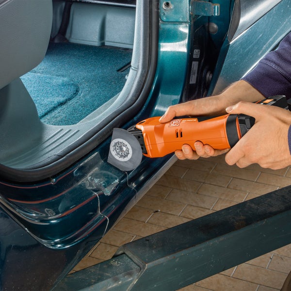 Fein Multimaster im Einsatz mit Tischklemme beim Bearbeiten eines Werkstücks