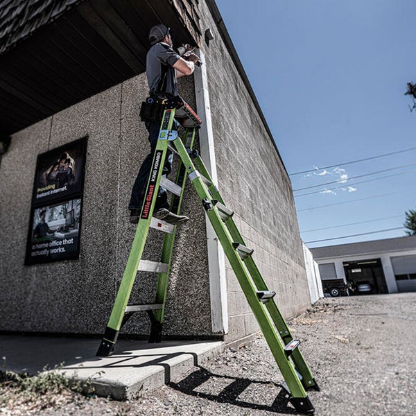 Handwerker arbeitet auf einer Little Giant King Kombo Multifunktionsleiter an einer Außenwand.
