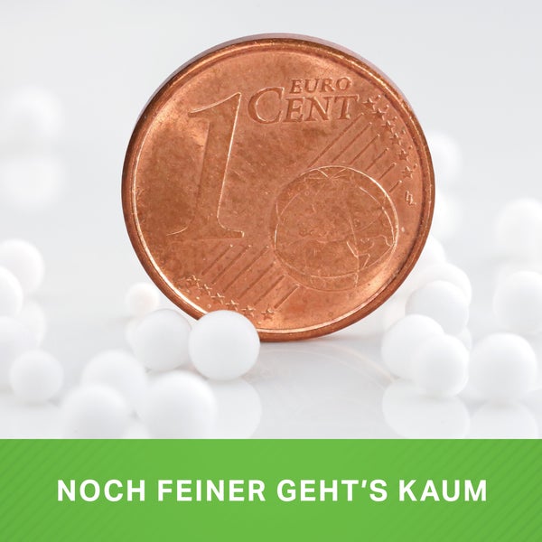 Ein Cent Münze im Vergleich mit kleinen Styroporkugeln zur Veranschaulichung der Feinheit