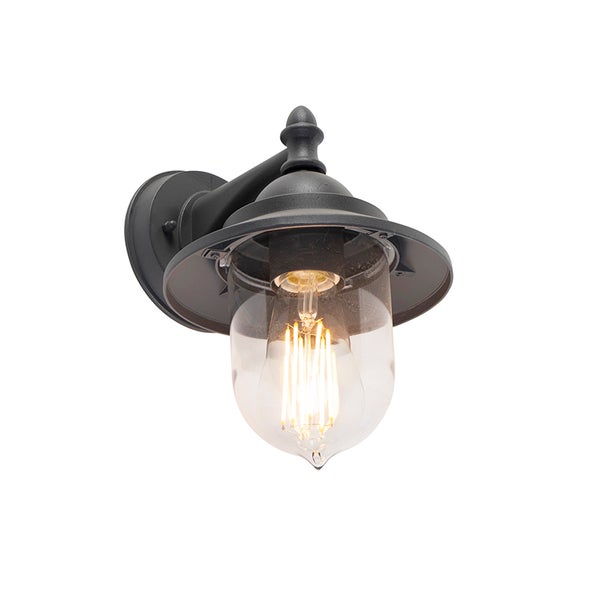 Klassische Außenwandleuchte aus schwarzem Metall mit klarem Glasschirm und eingeschaltetem Leuchtmittel.