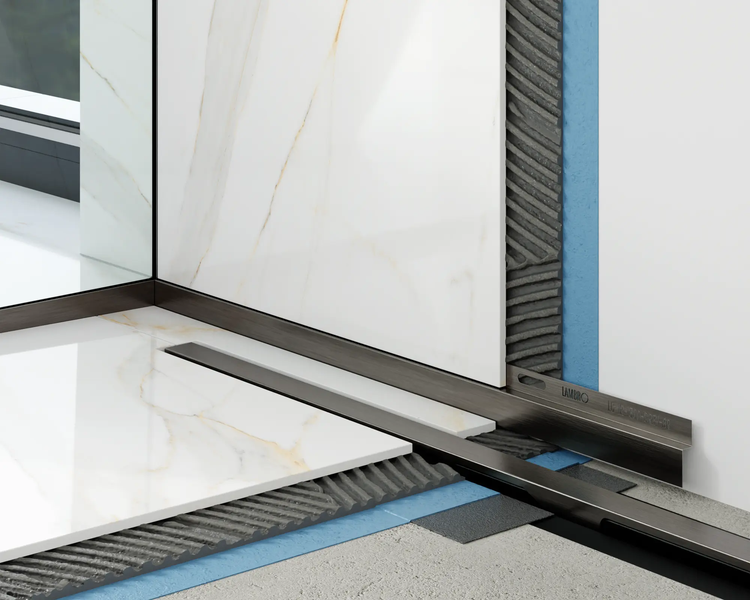 Montage eines Lambro Gefälleprofils zwischen Wandfliesen und Bodenfliesen in Marmoroptik mit Fliesenkleber und Abdichtung.