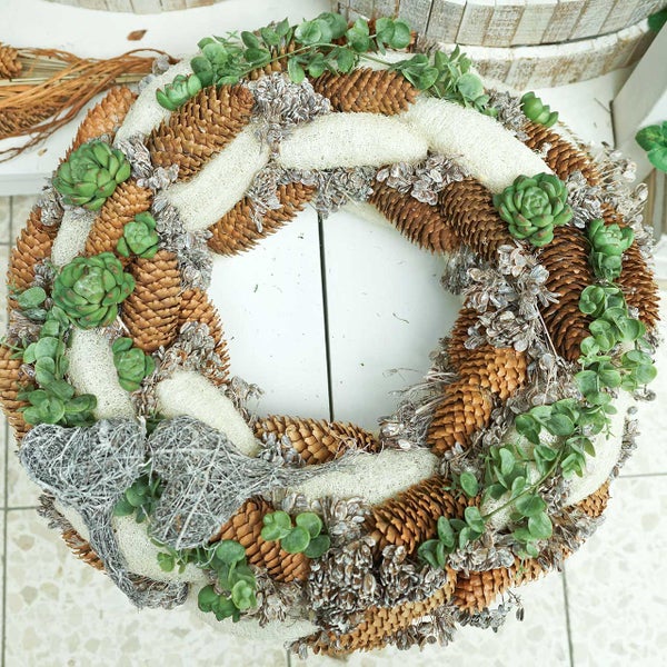Dekorativer Kranz aus Tannenzapfen, Luffa und Sukkulenten für den Innenbereich