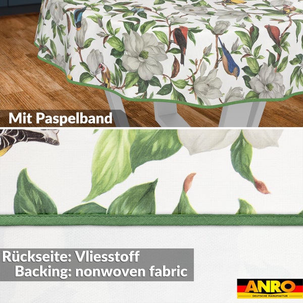Rundes Wachstuch mit Blumen- und Vogelmuster, eingefasst mit Paspelband und einer Rückseite aus Vliesstoff. ANRO Logo.
