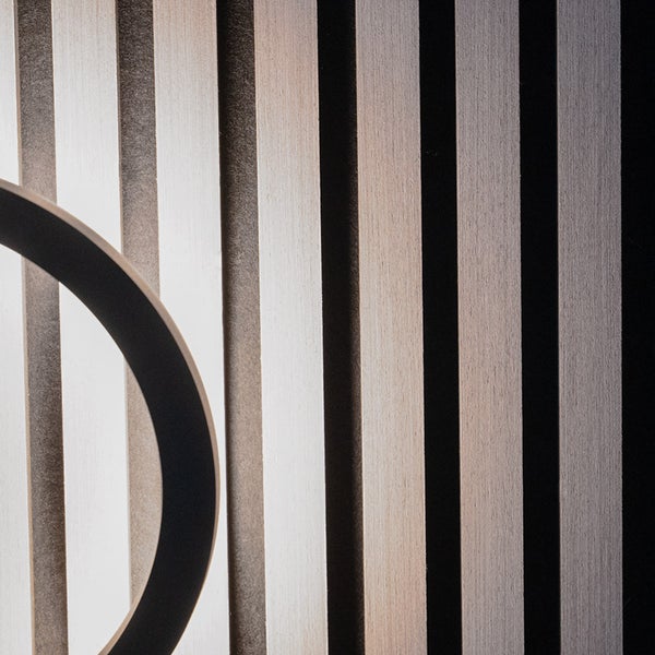 Akustikpaneel mit vertikalen Holzlamellen und Detail einer runden Leuchte.