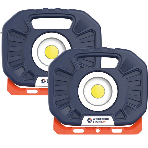 LED-Baustrahler auf Stativ beleuchtet eine dunkle Außenfassade bei Nacht.