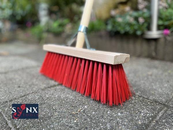 Kehrbesen mit Holzstiel und roten Borsten