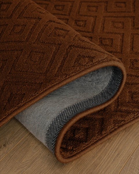 Teppich mit geometrischem Muster, weicher Struktur und rutschhemmender Unterseite auf Holzboden.