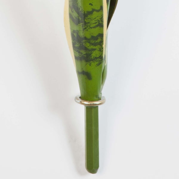 Detail der Basis eines künstlichen Sansevieria-Blattes mit Metallring am Stiel.