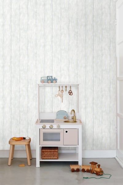 Spielküche mit Zubehör in einem Kinderzimmer mit Holztapete