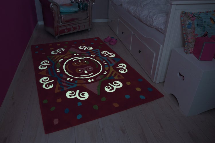 Rechteckiger Kinderteppich mit nachleuchtendem Sonnendesign im Kinderzimmer auf hellem Boden.