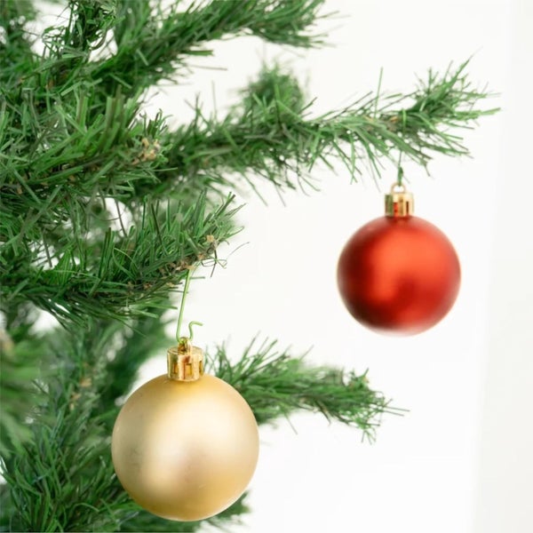 Nahaufnahme eines Weihnachtsbaums mit roter und goldener Kugel