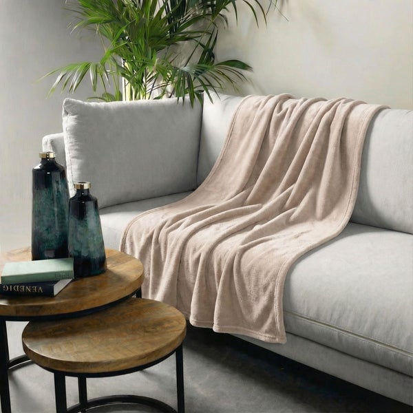 Wohnzimmer-Szene mit beiger Fleecedecke auf einem Sofa
