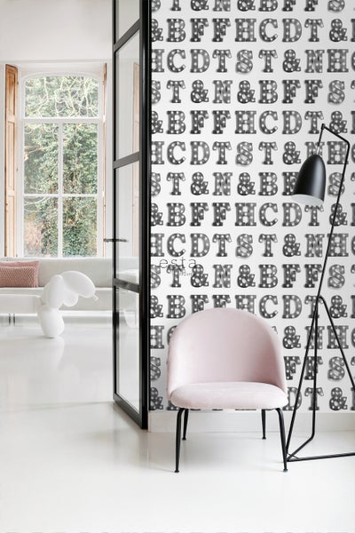 Innenraum mit Stuhl, Stehlampe und Tapete mit Buchstabenmuster