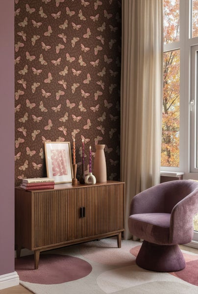 Wohnzimmer mit Tapete, Kommode und Sessel.