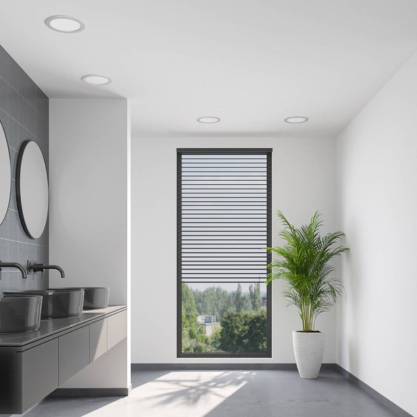 Modernes helles Badezimmer mit dunklen Aufsatzwaschbecken, runden Spiegeln und einem großen Fenster mit Außenjalousie.