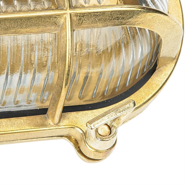 Nahaufnahme einer goldenen Außenleuchte mit Schutzgitter.