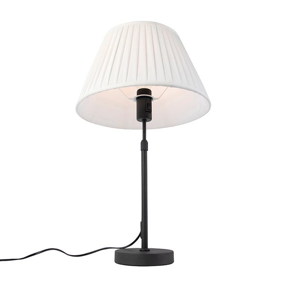 Tischleuchte mit plissiertem Stoffschirm und schwarzem Metallfuß.