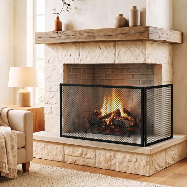 Dreiteiliges Kaminschutzgitter aus Metall vor einem gemauerten Kamin mit loderndem Feuer in einem gemütlichen Wohnzimmer.