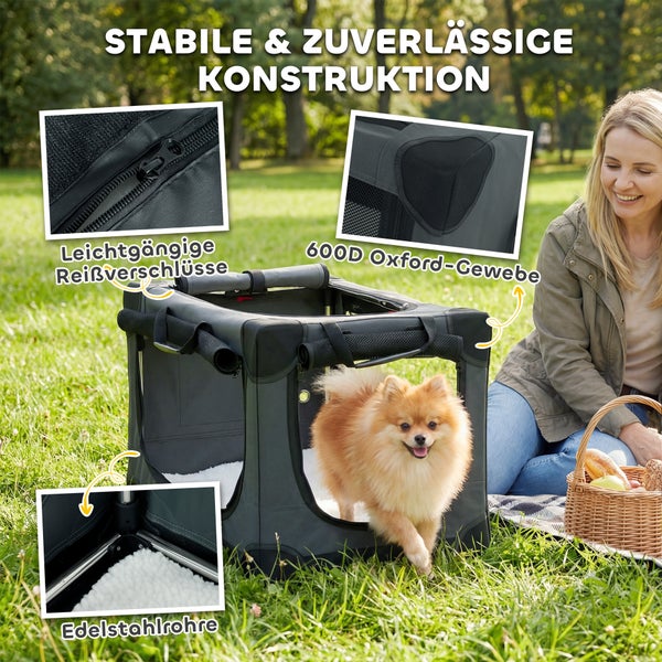 Hundetransportbox aus 600 Denier Oxford-Gewebe mit Edelstahlrahmen und Reißverschlüssen, im Park mit kleinem Hund und Person dargestellt.