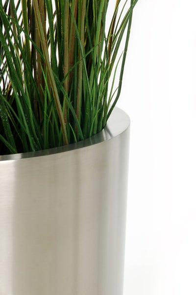 Künstliches Gras in einem zylindrischen Pflanzgefäß aus gebürstetem Edelstahl.