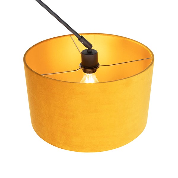 Runder Lampenschirm aus Samt in Gelb mit leuchtendem Leuchtmittel und schwarzer Fassung.