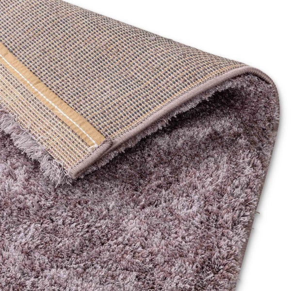 Hochflor-Teppich mit weicher Textur und sichtbarer gewebter Rückseite an einer umgeklappten Ecke.