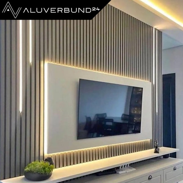 Wohnwand mit vertikalen Lamellenpaneelen und indirekter Beleuchtung hinter einem mittigen TV Panel in modernem Design.