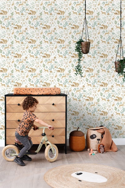 Kinderzimmer mit Mustertapete, Kommode, Kinderfahrrad und dekorativen Aufbewahrungskörben.