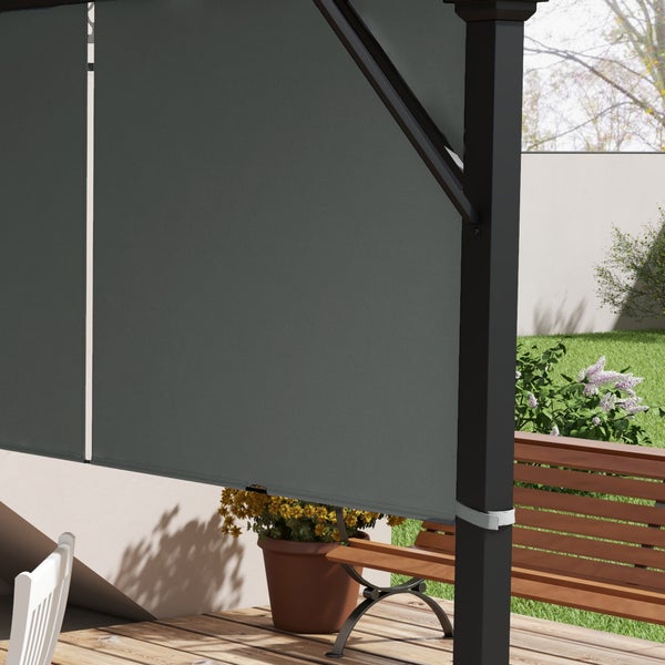 Seitenwand aus anthrazitfarbenem Stoff für eine Pergola, befestigt an einem schwarzen Metallrahmen im Garten auf einer Holzterrasse.