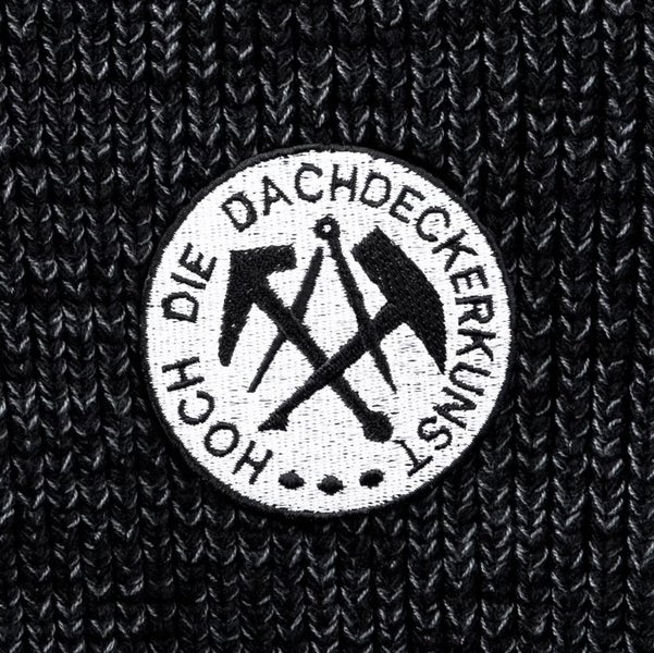 Aufnäher mit Zunftwappen der Dachdecker und Schriftzug Hoch die Dachdeckerkunst auf Strickgewebe.
