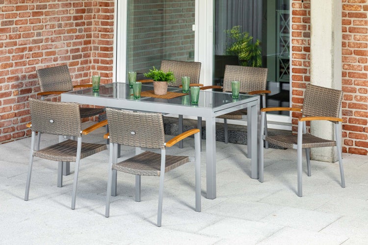 Gartenset bestehend aus einem rechteckigen Tisch mit Glasplatte und sechs Stühlen aus Polyrattan mit Armlehnen aus Holz auf einer Terrasse.