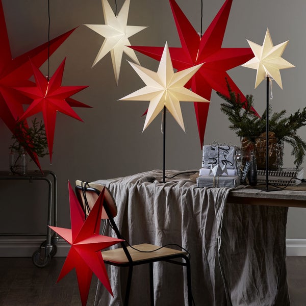 Dekoratives Arrangement mit leuchtenden Papiersternen in Rot und Weiß in einem Innenraum.