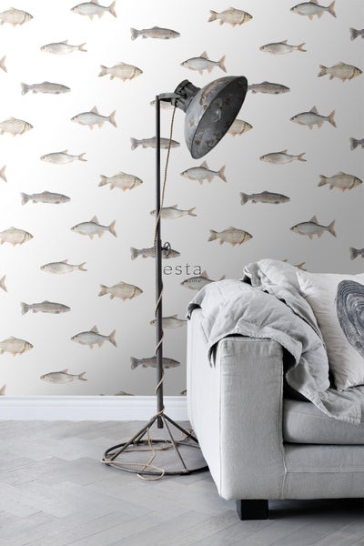 Dekoratives Interieur mit einer Stehlampe und einer Couch vor einer Tapete mit Fischmotiven.