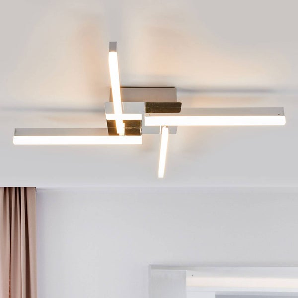 Moderne LED-Deckenleuchte mit vier versetzten, leuchtenden Armen aus Chrom und Kunststoff.