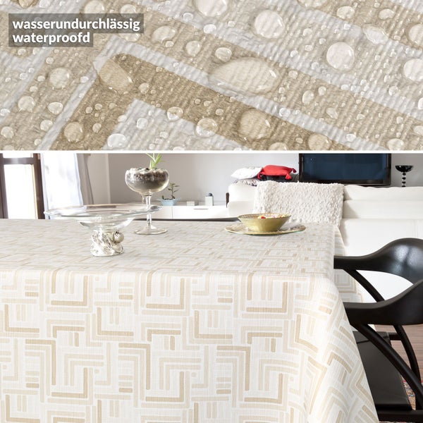 Wasserundurchlässige Tischdecke mit geometrischem Muster, Detailansicht von Wassertropfen auf dem strukturierten Stoff in einem Wohnzimmer.