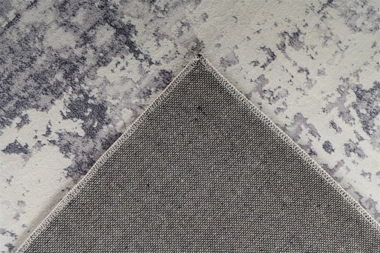 Teppich mit abstraktem Muster in Grau und Creme sowie Detailansicht der Rückseite mit geketteltem Rand.