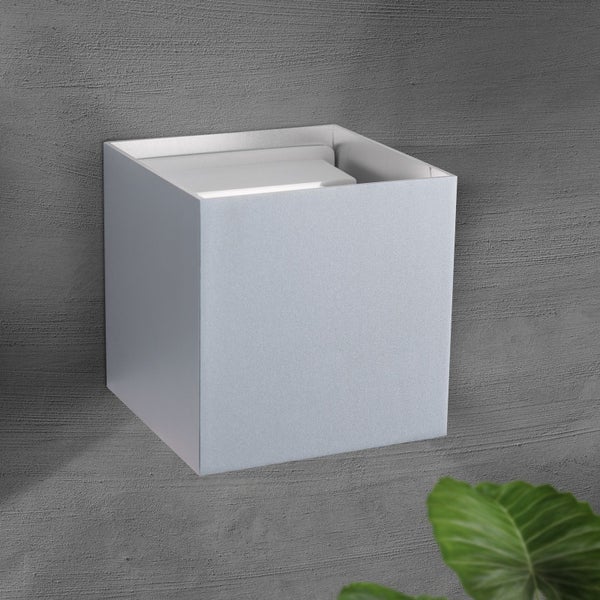Würfelförmige Wandleuchte an einer strukturierten Wand im modernen, minimalistischen Design.