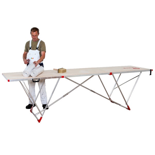 Tapeziertisch mit Arbeiter, Tapetenrollen und Bürste