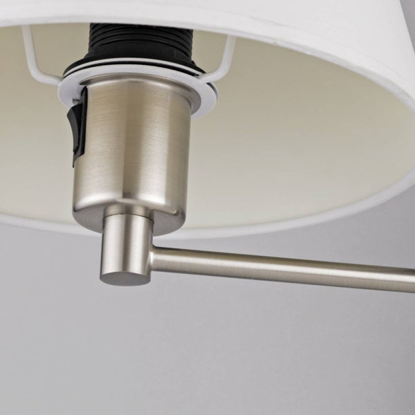 Detailansicht einer Lampe aus gebürstetem Metall mit Kippschalter, Fassung und weißem Stoffschirm.