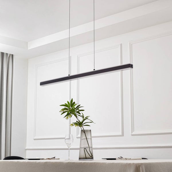 Moderne schwarze LED-Pendelleuchte über einem Esstisch in einem hellen, organisierten Raum mit Wandleisten und einer Pflanze in einer Vase.