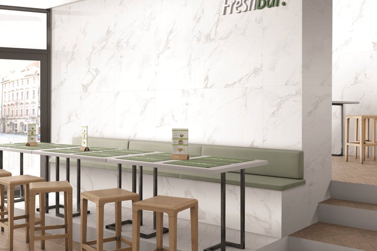 Heller Innenraum mit Marmorwandfliesen, Tischen und Stühlen für Gastronomie