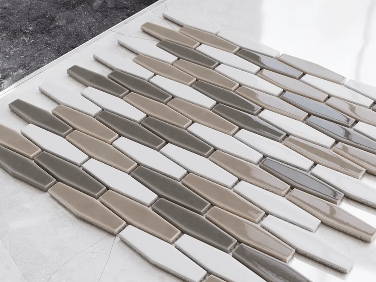 Mosaikfliesen in länglicher Sechseckform in Weiß, Beige und Grau mit glänzender Oberfläche.