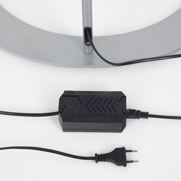 Netzteil und Netzstecker für eine Leuchte mit silbernem Fuß und schwarzem Kabel.