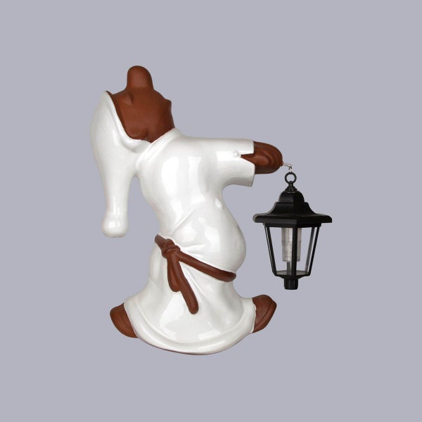 Braune Gartenfigur Zwerg im weißen Nachthemd mit einer schwarzen Laterne.