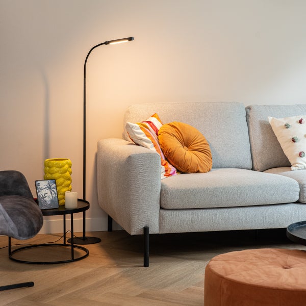 Wohnzimmer mit Sofa, Stehlampe und Beistelltisch