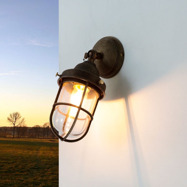 Wandleuchte mit Schutzgitter und Lampenschein